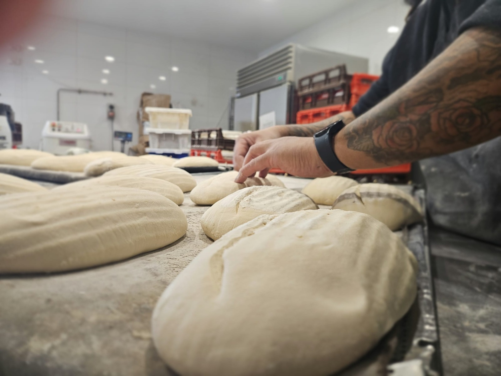 An Evoke baker shaping loaves by hand in the bakery